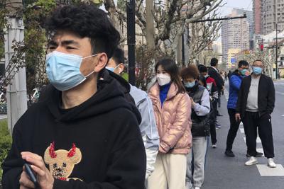 Residentes hacen fila para la primera ronda de pruebas masivas de detección del coronavirus, en el distrito de Jingan, en el oeste de Shanghái, China, el 1 de abril de 2022. (AP Foto/Chen Si)