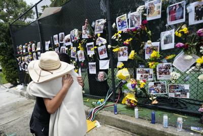 Dos personas se abrazan frente a un altar improvisado ubicado a las afueras de la iglesia católica de St. Joseph, el lunes 28 de junio de 2021, en Surfside, Florida (AP Foto/Gerald Herbert)