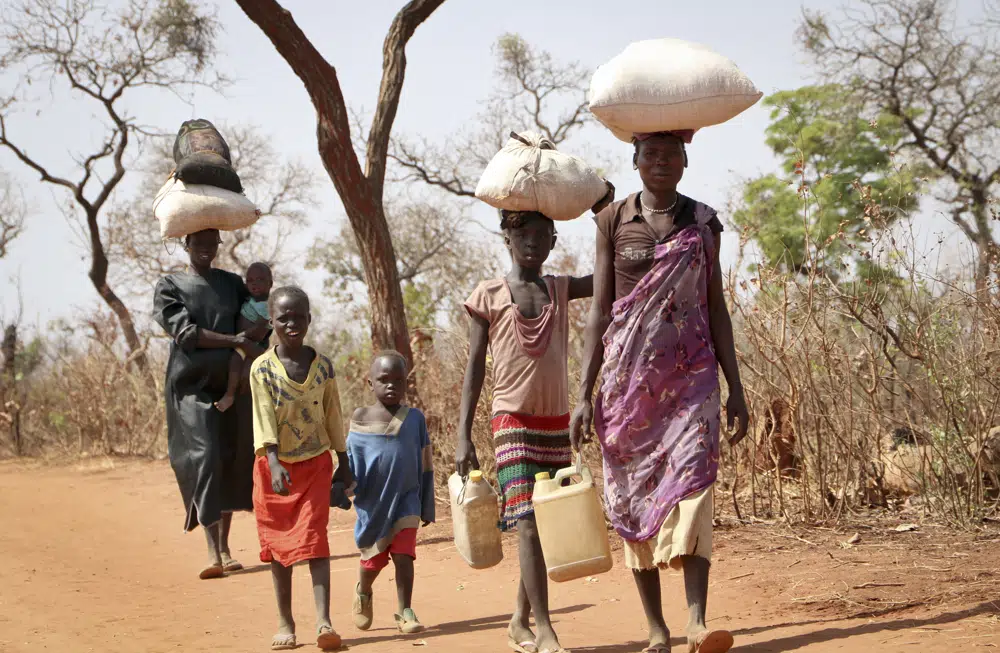 File - After walking for days, a refugee family arrives in Yida, South Sudan, Feb. 20, 2018. South Sudan's president on Wednesday, Feb. 22, 2023, urged the country's more than 2 million refugees to return home in his first meeting with displaced people since civil war erupted almost a decade ago. (AP Photo/Sam Mednick, file)