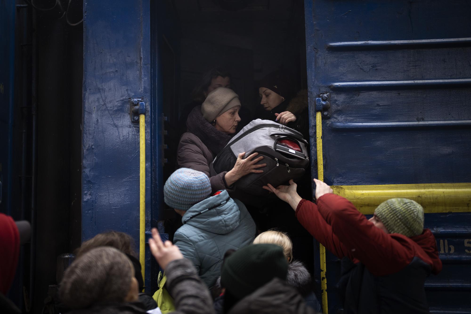 Women and children try to get onto a train bound for Lviv, at the Kyiv station in Ukraine, Thursday, March 3. 2022. (AP Photo/Emilio Morenatti)