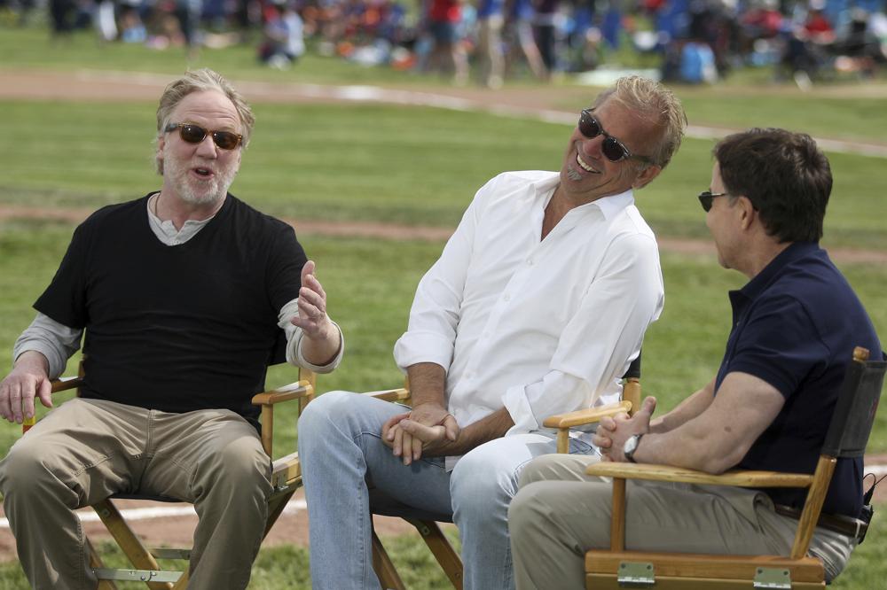 FILE - Bob Costas, right, talks with Timothy Busfield, left, and Kevin Costner while taping a segment during the 25th anniversary celebration of the "Field of Dreams" at the movie site near Dyersville, Iowa, in this Saturday, June 14, 2014, file photo. Three decades after Kevin Costner's character built a ballpark in a cornfield in the movie "Field of Dreams," the iconic site in Dyersville, Iowa, prepares to host the state's first Major League Baseball game at a built-for-the-moment stadium for the Chicago White Sox and New York Yankees. (AP Photo/The Telegraph Herald, Nicki Kohl)