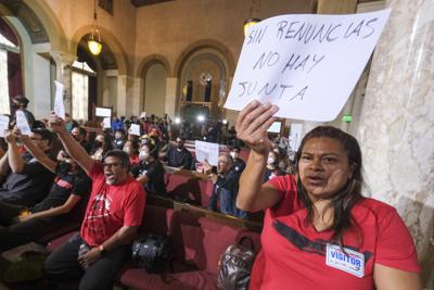 Ofelia Platon, a la derecha, de Oaxaca, sostiene un cartel que dice "Sin renuncias no hay junta" durante una protesta antes de la cancelación de una reunión de la junta municipal de Los Ángeles el miércoles 12 de octubre de 2022 en Los Ángeles. (AP Foto/Ringo H.W. Chiu)
