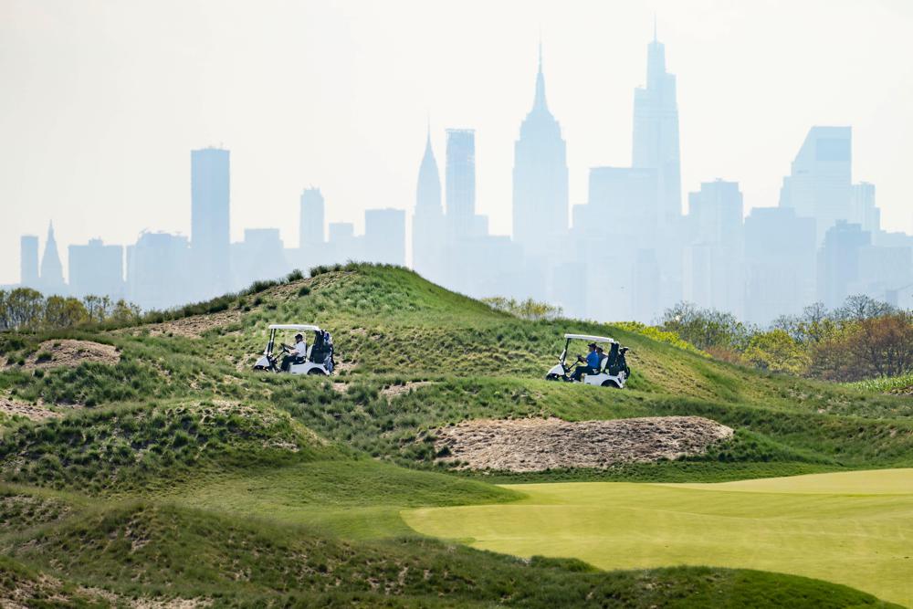 FILE - Patrons play the links as the Manhattan skyline is visible in the distance, at Trump Golf Links at Ferry Point in the Bronx borough of New York, May 4, 2021. The New York City-owned golf course, which is managed by former President Donald Trump's business, is expected to host a Saudi Arabia-supported women's tournament in October, city officials said Friday, Aug. 26, 2022. (AP Photo/John Minchillo, File)