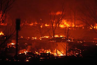 Homes burn as a wildfire rips through a development near Rock Creek Village, Thursday, Dec. 30, 2021, near Broomfield, Colo. An estimated 580 homes, a hotel and a shopping center have burned and tens of thousands of people were evacuated in wind-fueled wildfires outside Denver, officials said Thursday evening.  (AP Photo/David Zalubowski)