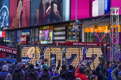 FILE - The 2022 sign that will be lit on top of a building on New Year's Eve is displayed in Times Square, New York, Monday, Dec. 20, 2021. New York City is readying to embrace the new year by reviving its annual New Year's Eve celebration in Times Square—limiting the number of people to about 15,000 in-person spectators. (AP Photo/Seth Wenig, File)