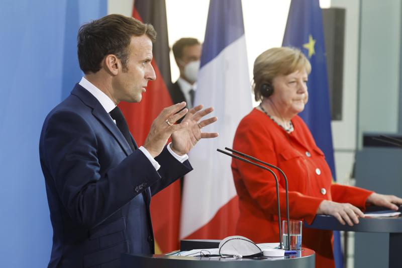 German Chancellor Angela Merkel, right, and French President Emmanuel Macron give a joint statement to journalists, at the chancellery in Berlin, Germany, Friday June 18, 2021. (Axel Schmidt/Pool via AP)