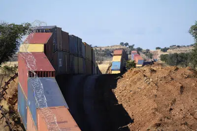 Una hilera de contenedores de carga apilados en la frontera entre Estados Unidos y México, el jueves 8 de diciembre de 2022 en la lejana sección de San Rafael Valley, Arizona. (AP Foto/Ross D. Franklin)