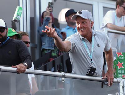 Greg Norman, CEO of LIV Golf, tosses a beer to spectators into the crowd surrounding the 18th green at the Portland Invitational LIV Golf tournament in North Plains, Ore., Saturday, July 2, 2022. (AP Photo/Steve Dipaola)
