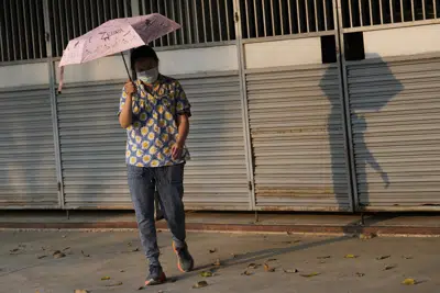 Una mujer sostiene un paraguas para protegerse del sol en Bangkok, Tailandia, el sábado 22 de abril de 2023. Las autoridades advirtieron a los residentes de toda Tailandia que evitaran las actividades al aire libre debido al calor extremo durante el fin de semana. (AP Photo/Sakchai Lalit)