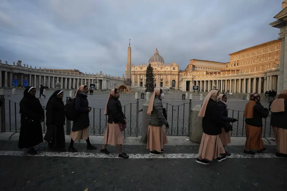 Nuns wait in a line to enter Saint Peter's Basilica at the Vatican where late Pope Benedict 16 is being laid in state at The Vatican, Monday, Jan. 2, 2023. Benedict XVI, the German theologian who will be remembered as the first pope in 600 years to resign, has died, the Vatican announced Saturday. He was 95. (AP Photo/Alessandra Tarantino)