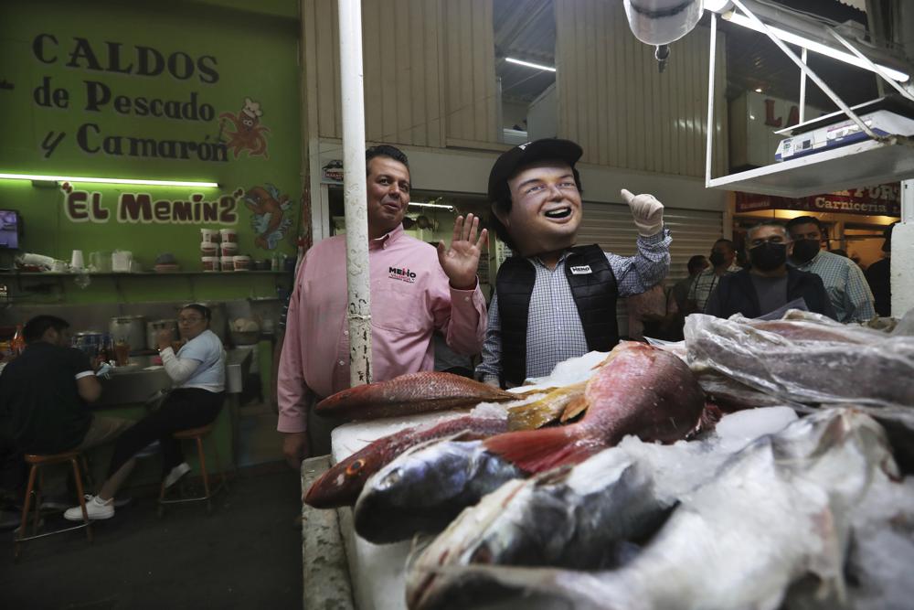 Guillermo Valencia, candidato a la alcaldía de Morelia por el Partido Revolucionario Institucional, hace campaña el viernes 21 de mayo de 2021 en un mercado de esa ciudad del estado de Michoacán, México. (AP Foto/Marco Ugarte)