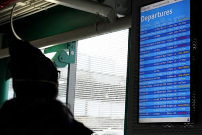 Una persona revisa la pantalla de vuelos salientes en el aeropuerto internacional O'Hare en Chicago, Illinois, el martes 28 de diciembre de 2021. (AP Foto/Nam Y. Huh)