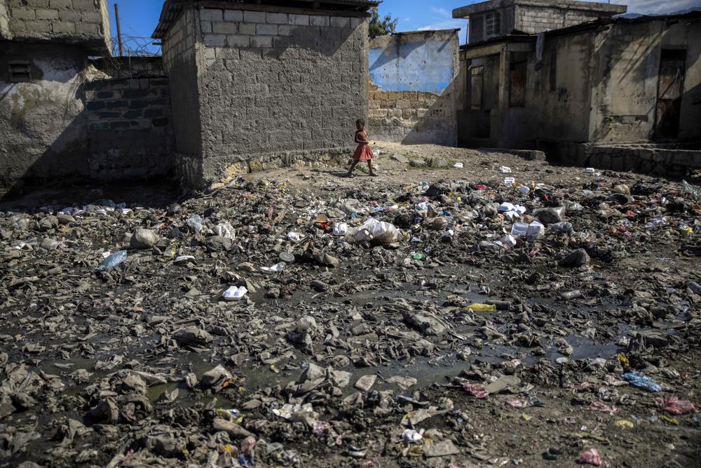 A child walks past piles of trash in La Saline district of Port-au-Prince, Haiti, Tuesday, Jan. 24, 2023. Current Haitian Prime Minister Ariel Henry has asked the U.N. to lead a military intervention, but many Haitians insist that's not the solution, citing past consequences of foreign intervention in Haiti. So far, no country has been willing to put boots on the ground. (AP Photo/Odelyn Joseph)