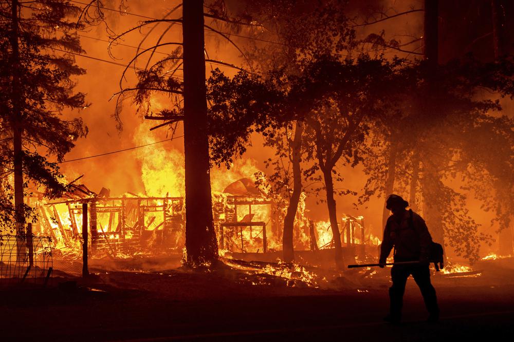 Un bombero combate las llamas que destruyen una casa en Plumas County (California)
