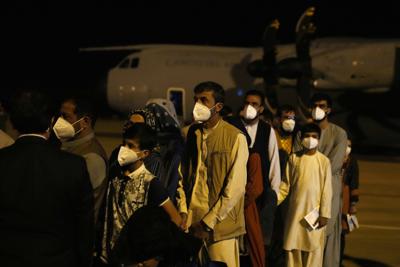 Un grupo de personas desembarca de un avión que sacó a ciudadanos españoles y afganos de Afganistán, en la base militar de Torrejón de Ardoz, en Madrid, el 19 de agosto de 2021. (AP Foto/Paul White)