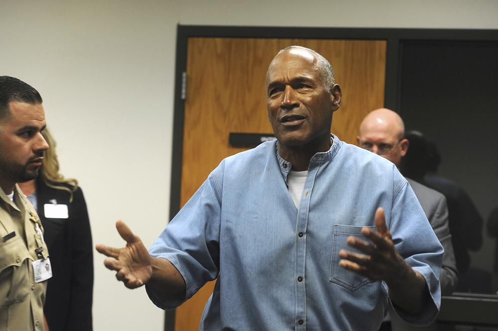 FILE - Former NFL football star O.J. Simpson reacts after learning he was granted parole at the Lovelock Correctional Center in Lovelock, Nev., on July 20, 2017. The 74-year-old former football hero, acquitted California murder defendant and convicted Las Vegas armed robber was granted good behavior credits and discharged from parole effective Dec. 1, the day after a hearing before the Nevada state Board of Parole, Kim Yoko Smith, spokeswoman for the Nevada State Police, said Tuesday, Dec. 14, 2021. (Jason Bean/The Reno Gazette-Journal via AP, Pool, File)