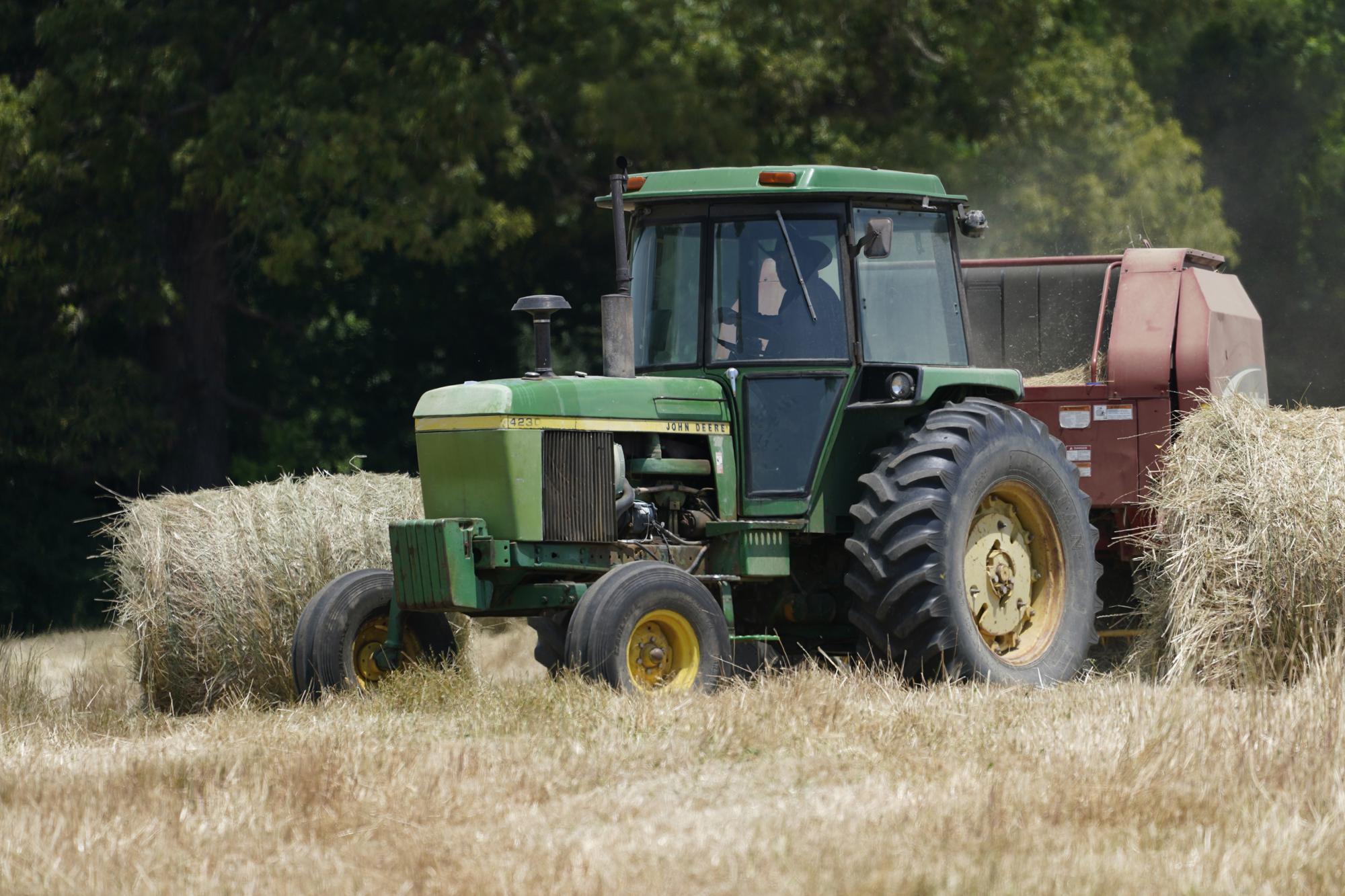 Farmer John Boyd Jr., runs his hay bailer at his farm in Boydton, Va., Thursday, May 27, 2021. Just two generations out of slavery, by 1910 Black farmers had amassed more than 16 million acres of land and made up about 14 percent of farmers. The fruit of their labors fed much of America. In 2021, they have fewer than 4.7 million acres. (AP Photo/Steve Helber)