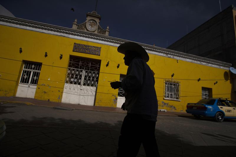 FILE - In this  June 27, 2020 file photo, a customer leaves a bank where people receive international money wires in Acatlan de Osorio, Mexico. Mexico's central bank said Thursday, July 1, 2021, that migrants living abroad sent home a record amount of money to Mexico in May, topping $4.5 billion per month for the first time.  (AP Photo/Fernando Llano, File)