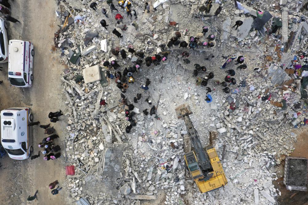 Civil defense workers and residents search through the rubble of collapsed buildings in the town of Harem near the Turkish border, Idlib province, Syria, Monday, Feb. 6, 2023. A powerful earthquake has caused significant damage in southeast Turkey and Syria and many casualties are feared. Damage was reported across several Turkish provinces, and rescue teams were being sent from around the country. (AP Photo/Ghaith Alsayed)