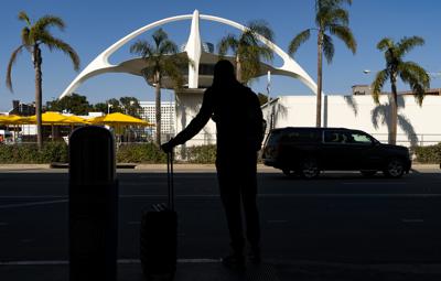 En esta imagen de archivo, tomada el 25 de noviembre de 2020, un viajero espera un auto en el Aeropuerto Internacional de Los Ángeles, en Los Ángeles. (AP Foto/Damian Dovarganes, archivo)