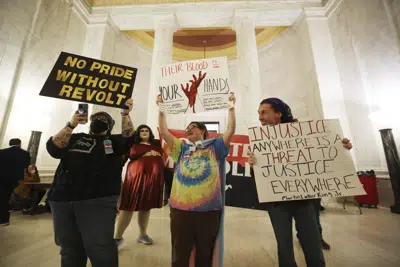 Los manifestantes sostienen carteles durante una manifestación contra HB2007 en el capitolio estatal en Charleston, W.Va., el 9 de marzo de 2023. HB2007 prohibiría la atención médica para niños trans en el estado. (AP Photo/Chris Jackson)