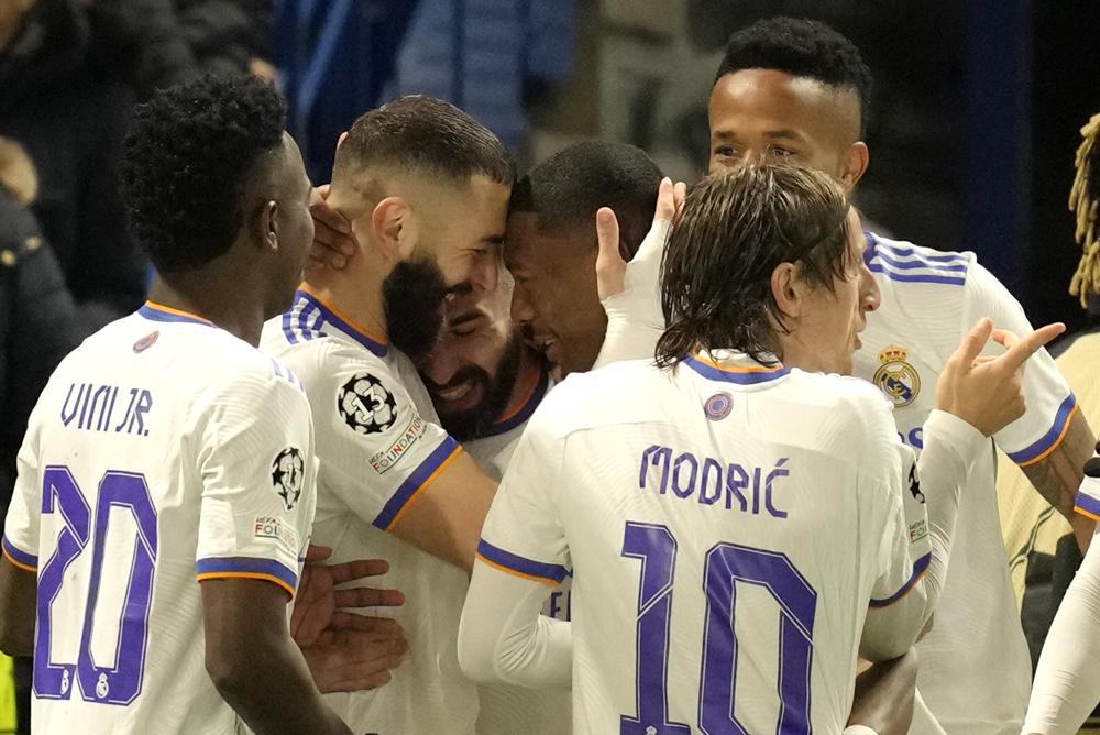 Karim Benzema celebra con sus compañeros tras anotar el tercer gol del Real Madrid ante Chelsea en la ida de los cuartos de final de la Liga de Campeones, el miércoles 6 de abril de 2022, en Londres. (AP Foto/Kirsty Wigglesworth)