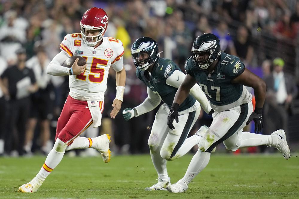 Kansas City Chiefs quarterback Patrick Mahomes (15) runs against Philadelphia Eagles defensive tackle Javon Hargrave (97) and linebacker Haason Reddick (7) during the second half of the NFL Super Bowl 57 football game, Sunday, Feb. 12, 2023, in Glendale, Ariz. (AP Photo/Ashley Landis)