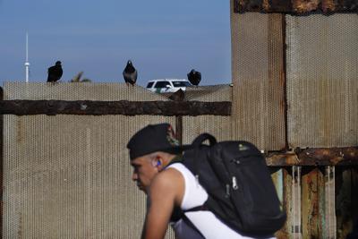 Un migrante espera por su oportunidad para cruzar la frontera después de que agentes de la
Oficina de Aduanas y Protección Fronteriza de Estados Unidos (CBP por sus iniciales en inglés) detuvo a un par de migrantes cruzando la frontera entre Estados Unidos y México, el miércoles 26 de enero de 2022, en Tijuana, México. (AP Foto/Marco Ugarte)