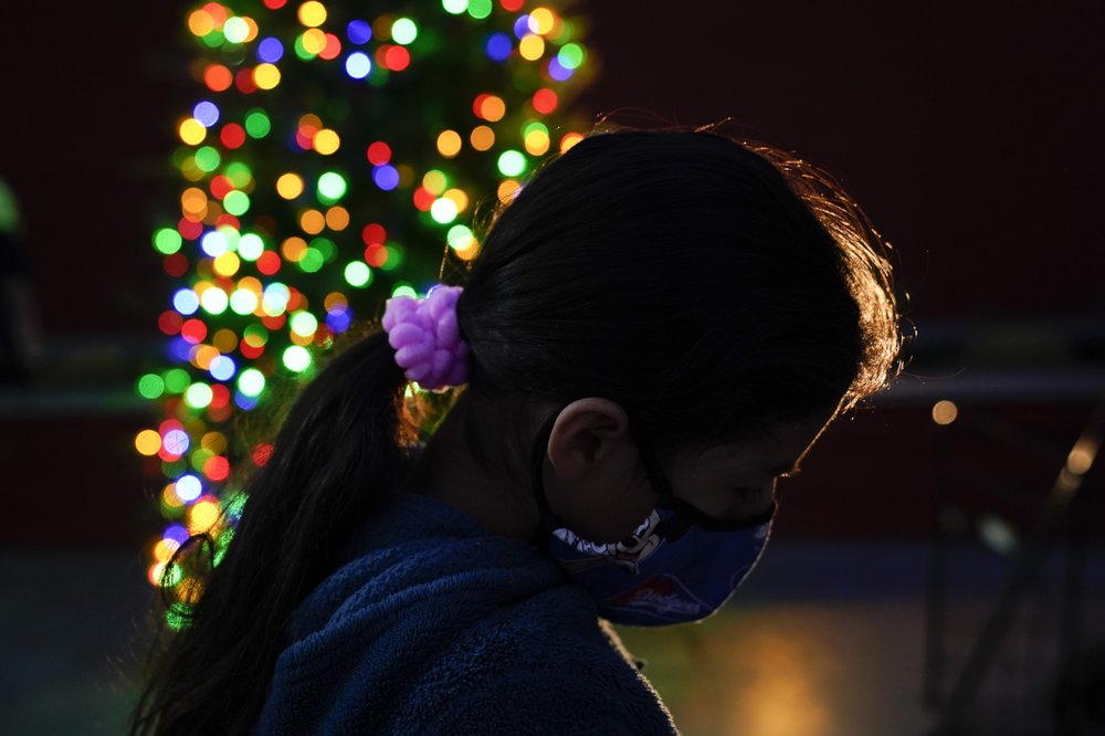 FILE - In this Dec. 17, 2020, file photo a girl chooses a toy at a holiday toy giveaway held at Los Angeles Boys & Girls Club in the Lincoln Heights neighborhood of Los Angeles. According to a survey from The Associated Press-NORC Center for Public Affairs Research that also finds some Americans are feeling a bit sadder, lonelier and less grateful than last year. (AP Photo/Jae C. Hong, File)