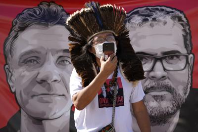 El líder indígena Kamuu Wapichana durante una protesta para pedir a las autoridades que amplíen los esfuerzos de búsqueda del periodista británico Dom Phillips, a la izquierda en la manta de atrás, y del experto indígena Bruno Pereira, frente al Ministerio de Justicia, en Brasilia, Brasil, el martes 14 de junio de 2022. (Foto AP/Eraldo Peres)