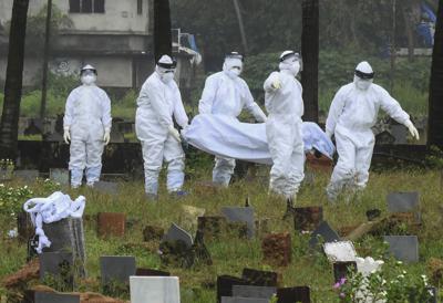 Personas en trajes de protección se preparan para cremar el cuerpo de un niño de 12 años que murió por causa del virus Nipha, el domingo 5 de septiembre de 2021, en Calcuta, en el estado de Kerala, India. (AP Foto/Shijith. K)