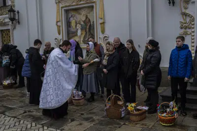 Fieles cristianos ortodoxos llevan sus canastas tradicionales de Pascua para que sean bendecidas, el domingo de Pascua en el recinto monástico de Pechersk Lavra el domingo 16 de abril de 2023. (AP Foto/Bernat Armangué)