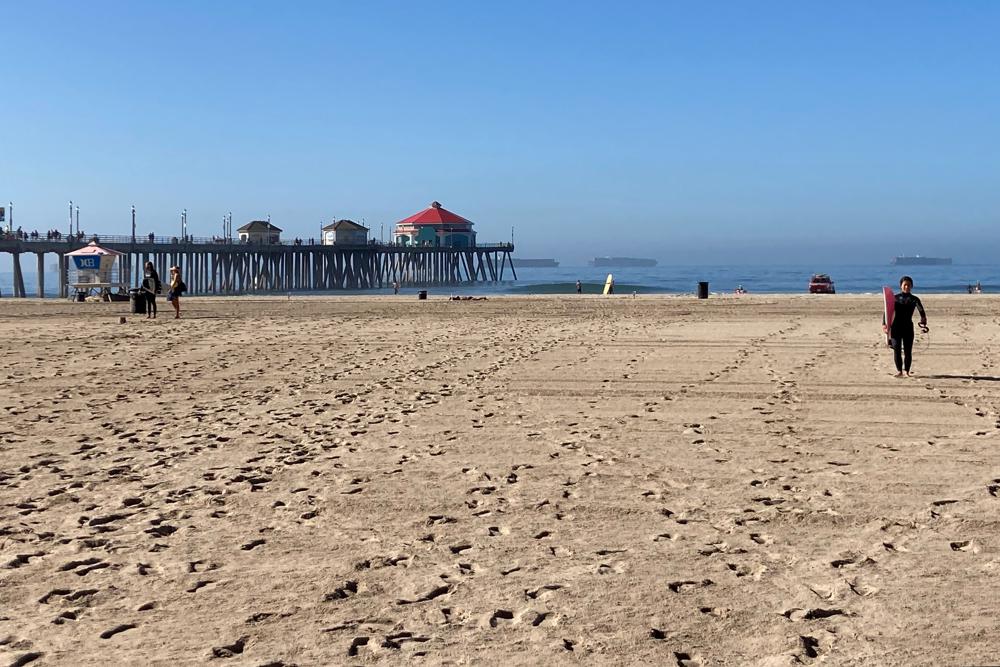 Surfers leave the water after lifeguards enforce the closure of the ocean in Huntington Beach, Calif., Sunday, Oct. 10, 2021. The water has been closed to surfing and swimming for a week since an offshore oil pipeline leaked crude into the water off the coast of Orange County. (AP Photo/Amy Taxin)