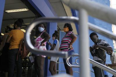 Personas hacen fila para retirar dinero de un programa de asistencia social en un banco público, el miércoles 17 de noviembre de 2021, en Río de Janeiro.  (AP Foto / Silvia Izquierdo)