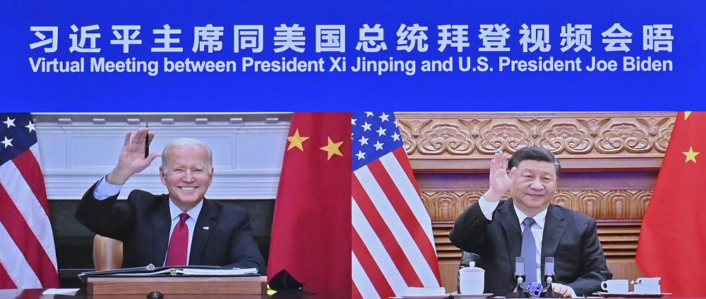 In this photo released by Xinhua News Agency Chinese President Xi Jinping, right and U.S. President Joe Biden appear on a screen as they hold a meeting via video link, in Beijing, China, Tuesday, Nov. 16, 2021. President Joe Biden opened his virtual meeting with China's President Xi Jinping by saying the goal of the two world leaders should be to ensure that competition between the two superpowers "does not veer into conflict." (Yue Yuewei/Xinhua via AP)