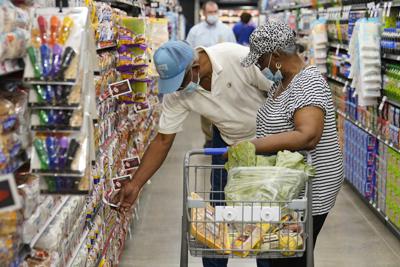 ARCHIVO - Ray Carter, izquierda, y Bobbie Carter hacen compras en la tienda de alimentos Homeland en Oklahoma City, 1 de septiembre de 2021. A los consumidores que enfrentan aumentos de precios en productos hechos con trigo y maíz les aguardan mayores penurias al caer la oferta global debido a la invasión rusa de Ucrania. (AP Foto/Sue Ogrocki, File)