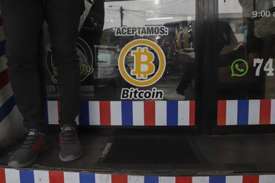 ARCHIVO - "Aceptamos Bitcoin" se anuncia en una barbería en Santa Tecla, El Salvador, el 4 de septiembre de 2021. El FMI instó al gobierno de El Salvador el martes 25 de enero de 2022 a eliminar el Bitcoin como moneda de curso legal. (AP Foto/Salvador Melendez, Archivo)