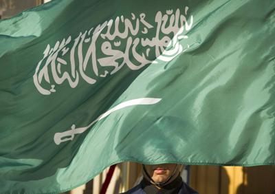 Fotografía de archivo del 22 de marzo de 2018 de un miembro de una guardia de honor siendo cubierto parcialmente por la bandera de Arabia Saudí en Washington, D.C. (AP Foto/Cliff Owen, Archivo)