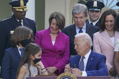El presidente Joe Biden habla con Logan y Abigail Evans, hijos del policía del Capitolio William "Billy" Evans, el jueves 5 de agosto de 2021 durante la firma de un proyecto de ley en la Rosaleda de la Casa Blanca, en Washington. El proyecto concede Medallas de Oro del Congreso a policías que protegieron a legisladores durante el asalto al Capitolio el 6 de enero. Detrás del mandatario se encuentran Robert Contee, jefe del Departamento de la Policía Metropolitana; la senadora demócrata Amy Klobuchar; el senador republicano Roy Blunt; el agente Daniel Hodges del Departamento de la Policía Metropolitana y la vicepresidenta Kamala Harris. (AP Foto/Susan Walsh)