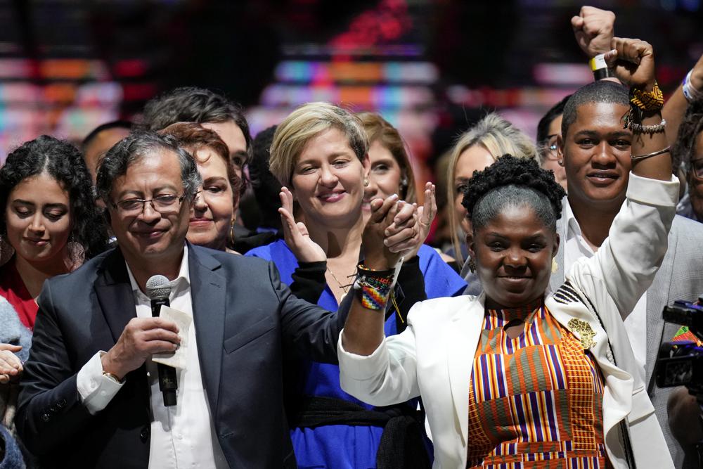 Former rebel Gustavo Petro, left, his wife Veronica Alcocer, back center, and his running mate Francia Marquez, celebrate before supporters after winning a runoff presidential election in Bogota, Colombia, Sunday, June 19, 2022. (AP Photo/Fernando Vergara)