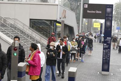 La fila de personas para ponerse la vacuna contra el coronavirus, en el Estadio Tottenham Hotspur en el norte de Londres, el 20 de junio del 2021. (Yui Mok/PA via AP)