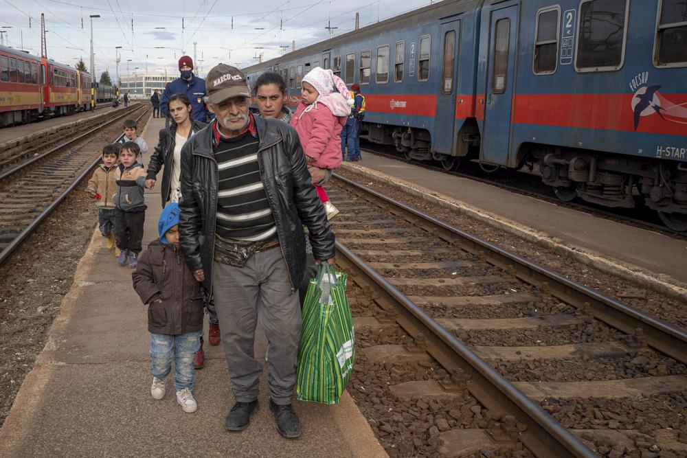 اللاجئون الفارون من الحرب من أوكرانيا المجاورة يسيرون على رصيف بعد نزولهم من قطار في زاهوني ، المجر ، الأربعاء ، 2 مارس / آذار 2022. في محطة القطار في بلدة زاهوني المجرية يوم الأربعاء ، أكثر من 200 أوكراني من ذوي الإعاقة - من سكان منزلين للرعاية في العاصمة الأوكرانية كييف - نزلوا وسط الرياح الباردة لمنصة القطار بعد هروب شاق من أعمال العنف التي تجتاح أوكرانيا.  (AP Photo / Balazs Kaufmann)