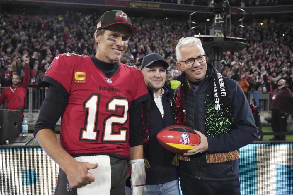 El mariscal de campo de los Tampa Bay Buccaneers, Tom Brady (12), posa para una foto después de un partido de fútbol americano de la NFL contra los Seattle Seahawks, el sábado 13 de noviembre de 2021, en Munich, Alemania.  (Foto AP/Matthias Schrader)