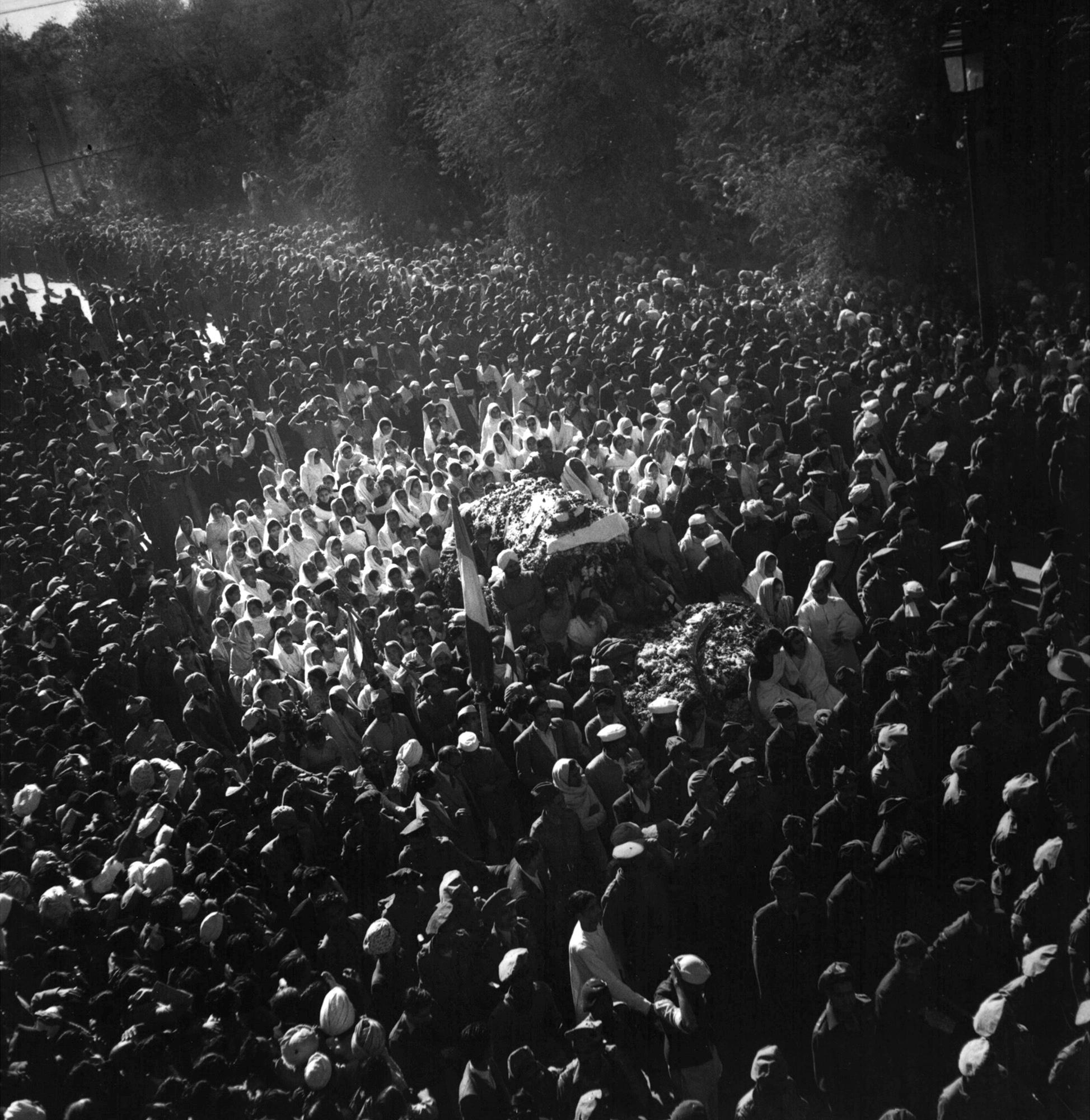 ARQUIVO - O corpo do líder indiano assassinado Mahatma Gandhi, coberto com pétalas de rosa, é levado para o local de sua cremação em Nova Delhi, 31 de janeiro de 1948. (AP Photo/Max Desfor, Arquivo)