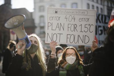 ARCHIVO - Gente en una manifestación de la Huelga del Clima en Zúrich, Suiza, el 6 de noviembre de 2021. El cartel dice "Error 404 error. No se encuentra un plan para 1,5 grados". Detener el calentamiento en torno a los 1,5 grados evitaría o al menos reduciría algunos de los efectos más catastróficos en el clima, y para algunas personas es una cuestión de vida o muerte, según han señalado los expertos en muchos reportes. (Michael Buholzer/Keystone via AP, Archivo)