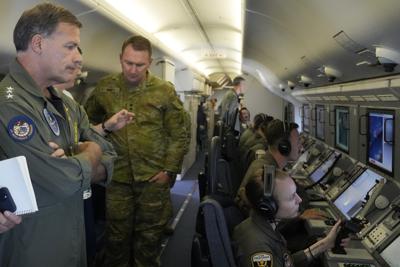 El almirante John C. Aquilino (i), comandante de las fuerzas estadounidenses en la región Indo-Pacífico, abordo de un avión de reconocimiento sobre el Mar de la China Meridional el 20 de marzo del 2022.  (Foto AP/Aaron Favila)