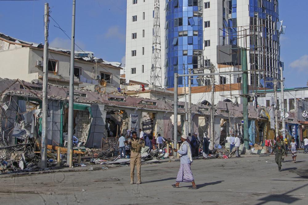 Security forces patrol next to destroyed buildings at the scene, a day after a double car bomb attack at a busy junction in Mogadishu, Somalia Sunday, Oct. 30, 2022. Somalia's president says multiple people were killed in Saturday's attacks and the toll could rise in the country's deadliest attack since a truck bombing at the same spot five years ago killed more than 500. (AP Photo/Farah Abdi Warsameh)
