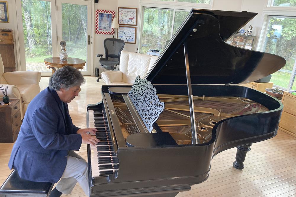 Robert Friedman plays a Steinway grand piano once owned by Thomas Edison, with possible bite marks from the inventor visible, on Sept. 28, 2022, in Woodstock, N.Y. Edison, who was hard of hearing, bit into phonographs and pianos to help him better experience music. Friedman purchased the piano last year and hopes to find a home for it where it can be seen by the public. (AP Photo/Michael Hill)