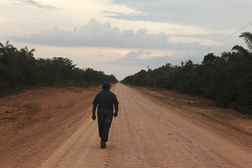 A man walks down an unpaved stretch of highway BR-319 in the Brazilian Amazon between the cities of Manaus and Porto Velho on Aug. 10, 2018. In a decision that critics have labeled dangerous, Brazil's government granted a preliminary environmental permit for the paving of the controversial highway that cuts through one of the Amazon rainforest’s most preserved areas. (AP Photo/Fabiano Maisonnave)