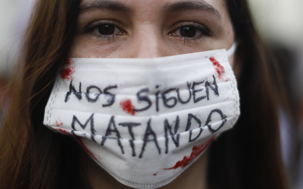Una mujer usa una mascarilla para frenar la propagación de COVID-19 con un texto que dice en español "Nos siguen matando", durante una manifestación para conmemorar el Día Internacional de la Mujer en Buenos Aires, Argentina, el lunes 8 de marzo de 2021. (AP Foto/Natacha Pisarenko)